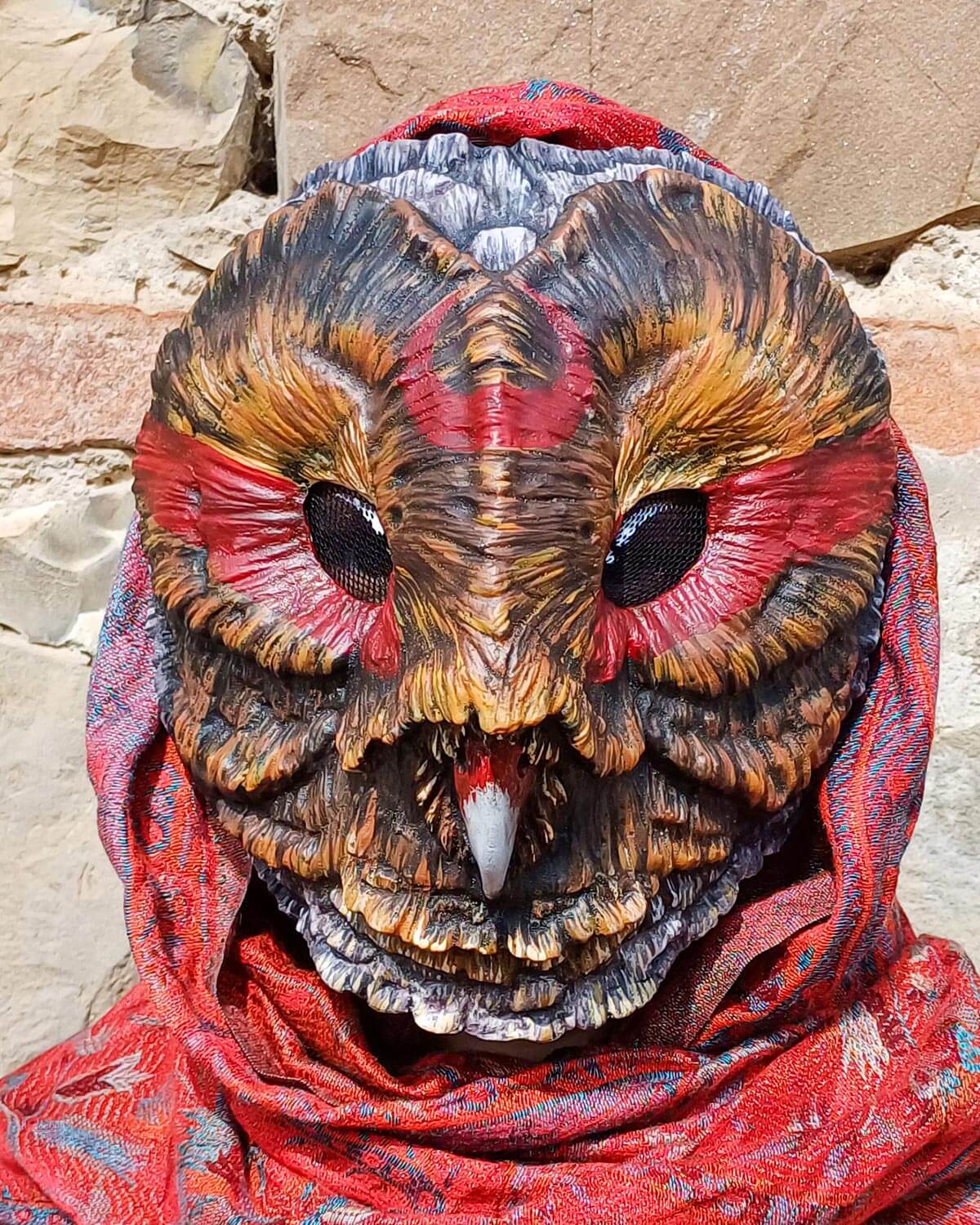 Shaman Barn Owl mask resting on a natural surface, emphasizing its handcrafted appearance and connection to nature