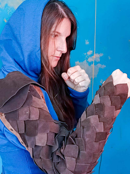 Close-up of the dark brown leather scales on the Gladiator Arm Armour, highlighting the texture and craftsmanship.