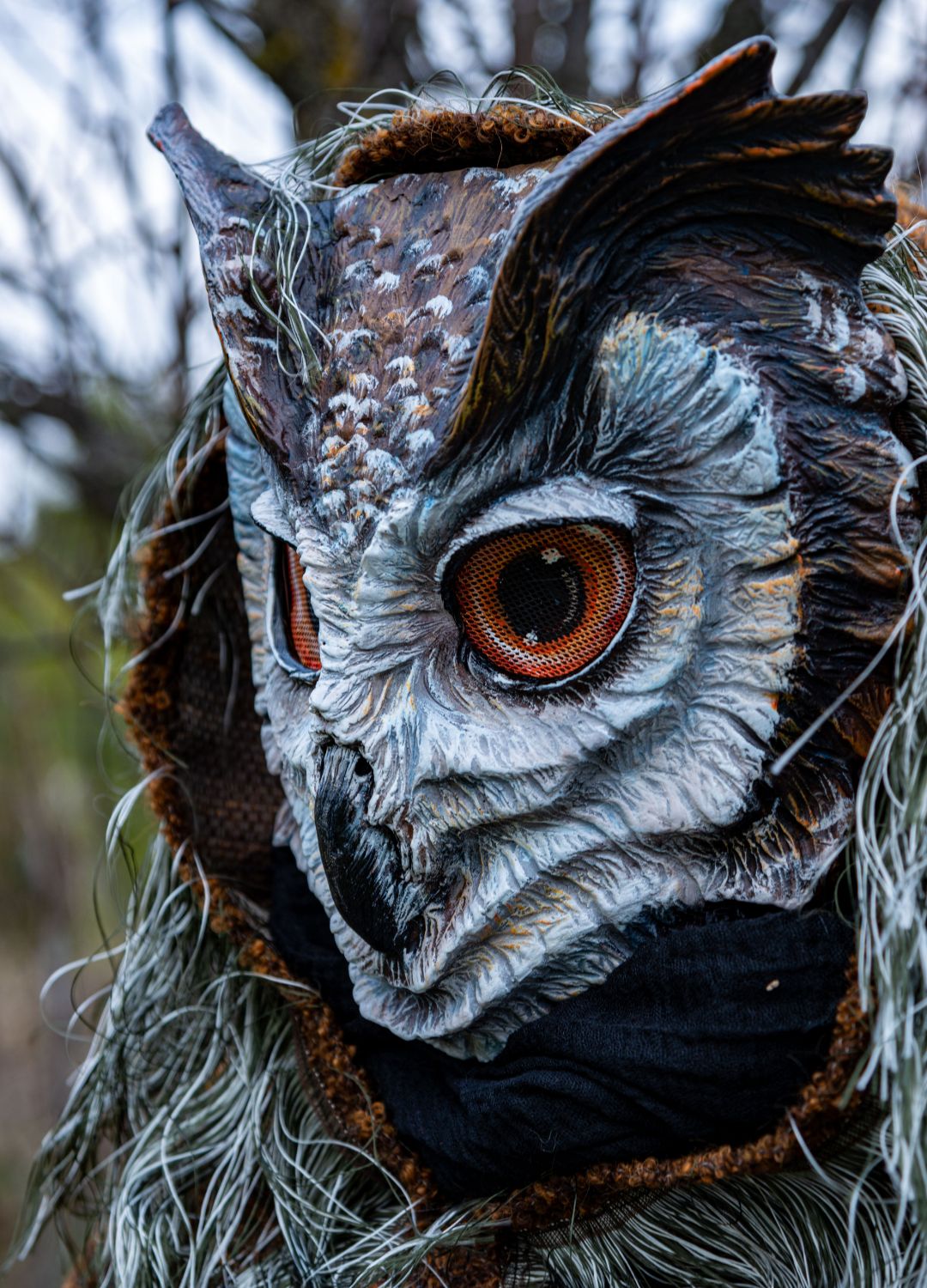 A close-up of the great horned owl mask, conveying a sense of mystery and power.