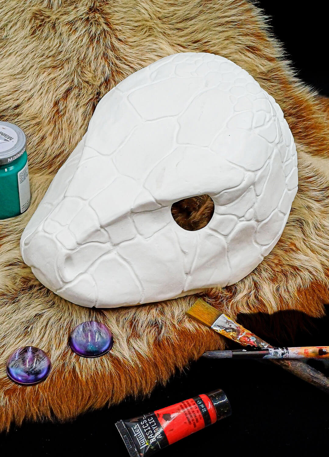 Unpainted snake mask with a pre-drawn pencil cut line for eye opening.