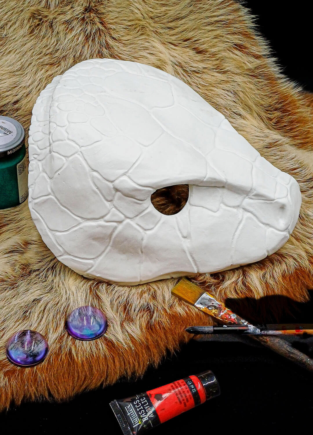 Unfinished snake mask with included resin eye half-spheres, ready for painting and installation.
