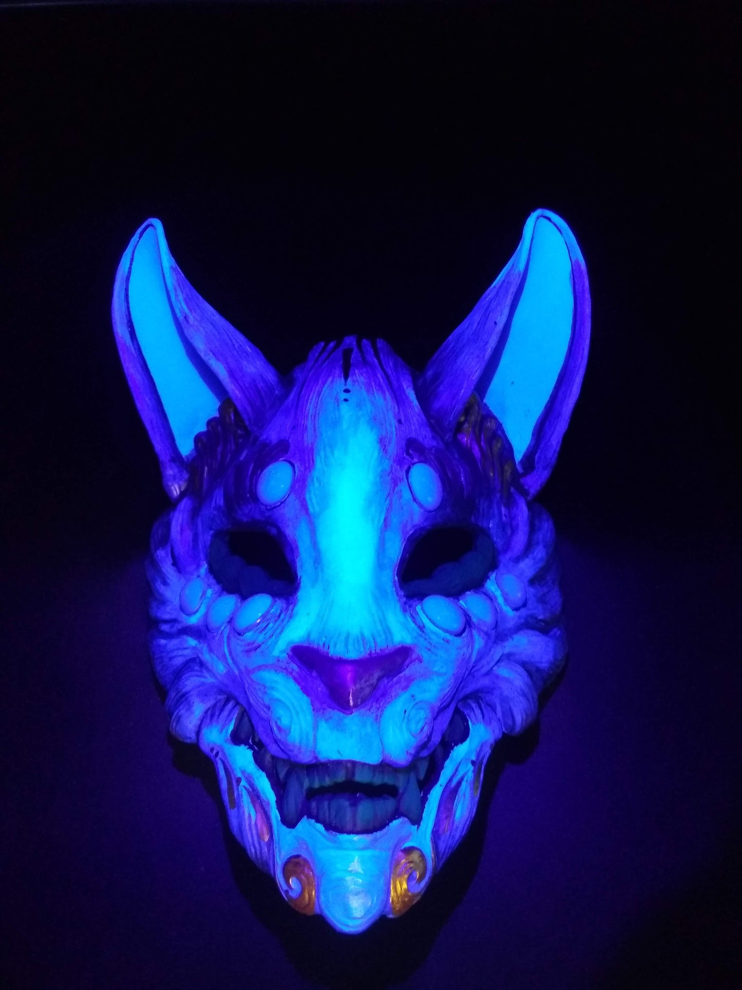 Handmade resin Kitsune mask painted with vibrant fluorescent pigments.
