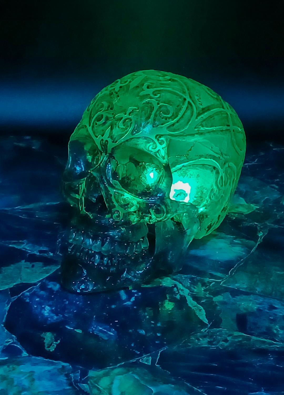 Glow-in-the-dark skull in dark room, luminous effect, fluorescent resin skul
