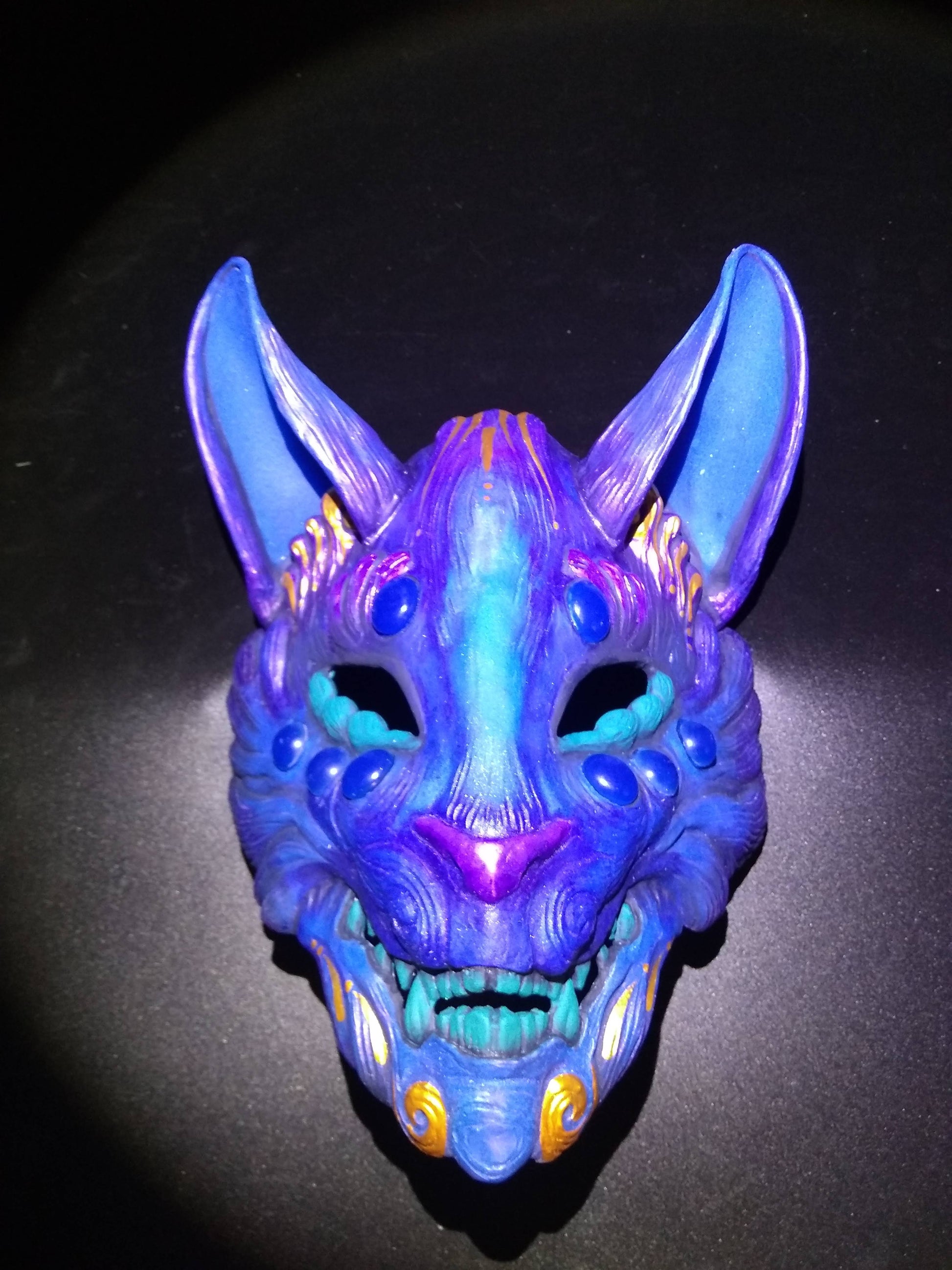 Japanese fox spirit mask with a bright fluorescent paint finish.
