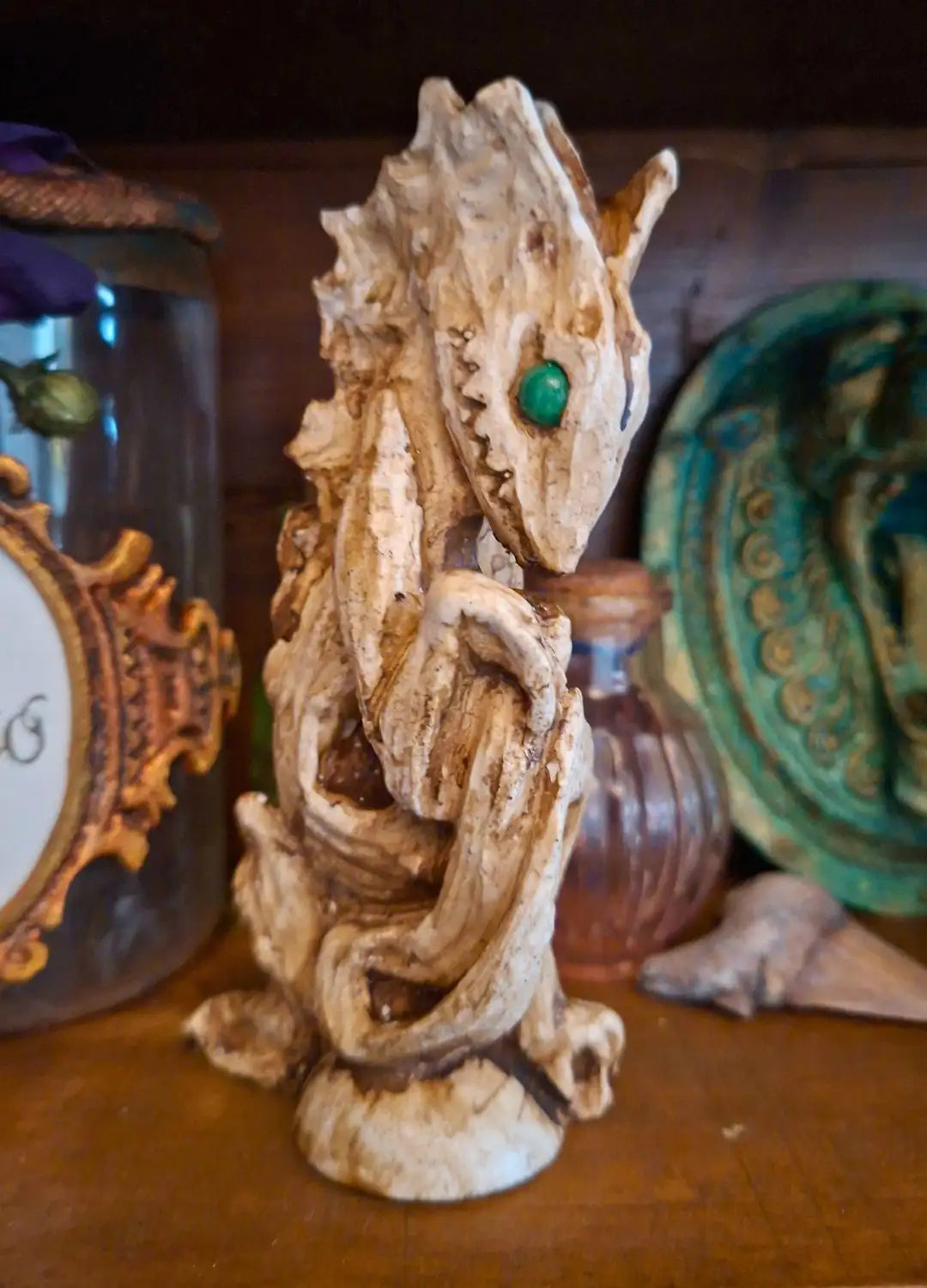 Three-quarters shot of the handmade Dagon Idol ancient deity sculpture with layered bone pigments, arranged in a dark fantasy setting.