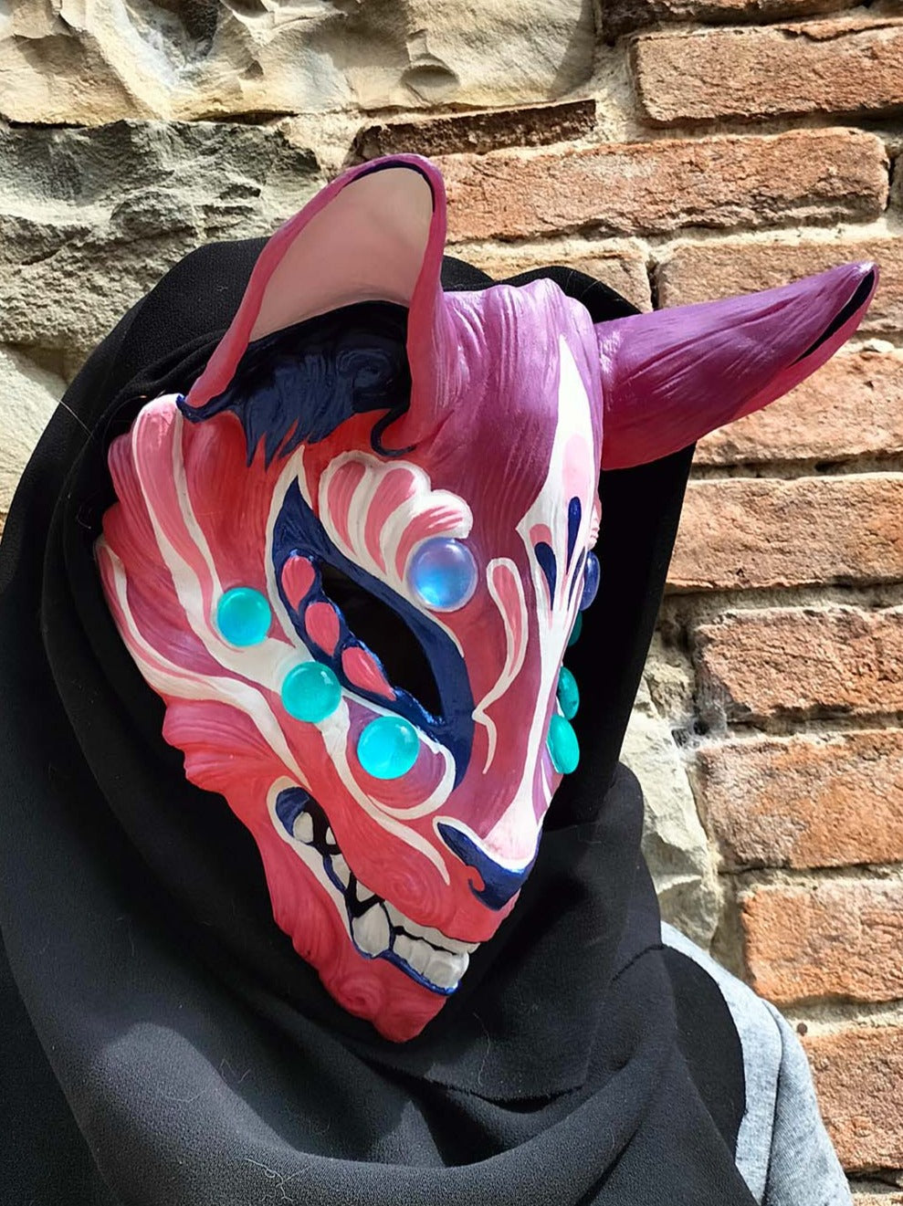 detailed view of the resin craftsmanship and color-changing pigments in the Kitsune mask.
