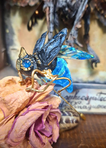 Close-up of the illuminated fantasy brooch showing the glowing transparent resin abdomen powered by a hidden integrated LED light.