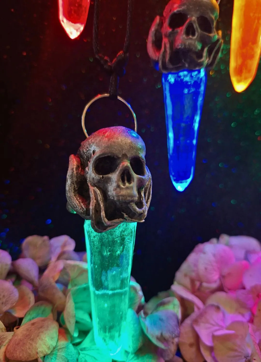 Close-up of the detailed hand-sculpted resin skull centerpiece on a mystical pendant charm made by Chimerical Dragonfly.