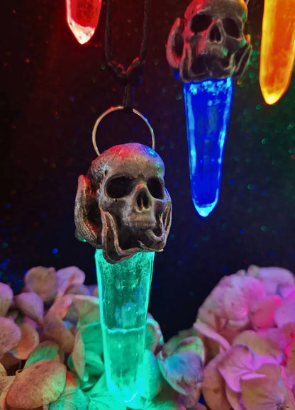 Close-up of the detailed hand-sculpted resin skull centerpiece on a mystical pendant charm made by Chimerical Dragonfly.