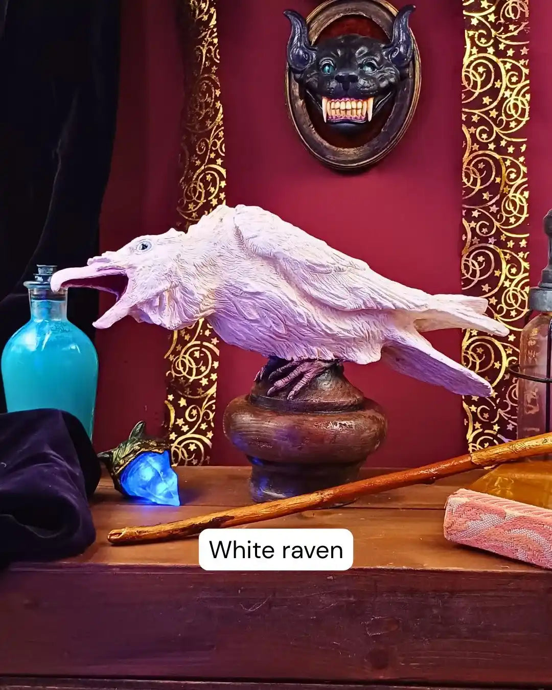 Ivory-colored white raven statue in a mystical pose, captured in a handcrafted cabinet of curiosities display with velvet and lanterns.