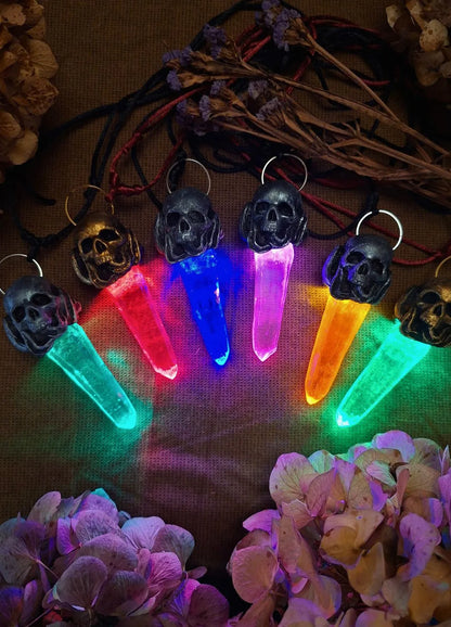 The glowing soulbound crystal necklace displayed on a wooden stand inside a cabinet of curiosities shelf as dark academic skull decor.
