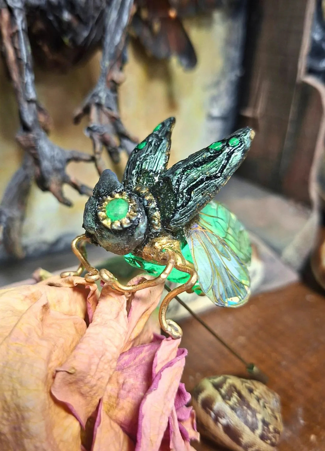 Detailed view of the polyurethane resin body and aluminum wire legs of a handmade steampunk brooch by Chimerical Dragonfly.
