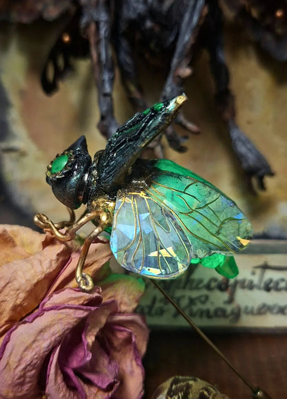 Aetherwing Mechanical insect brooch placed on a bookshelf as a dark academia home decor accent and fantasy worldbuilding collectible.