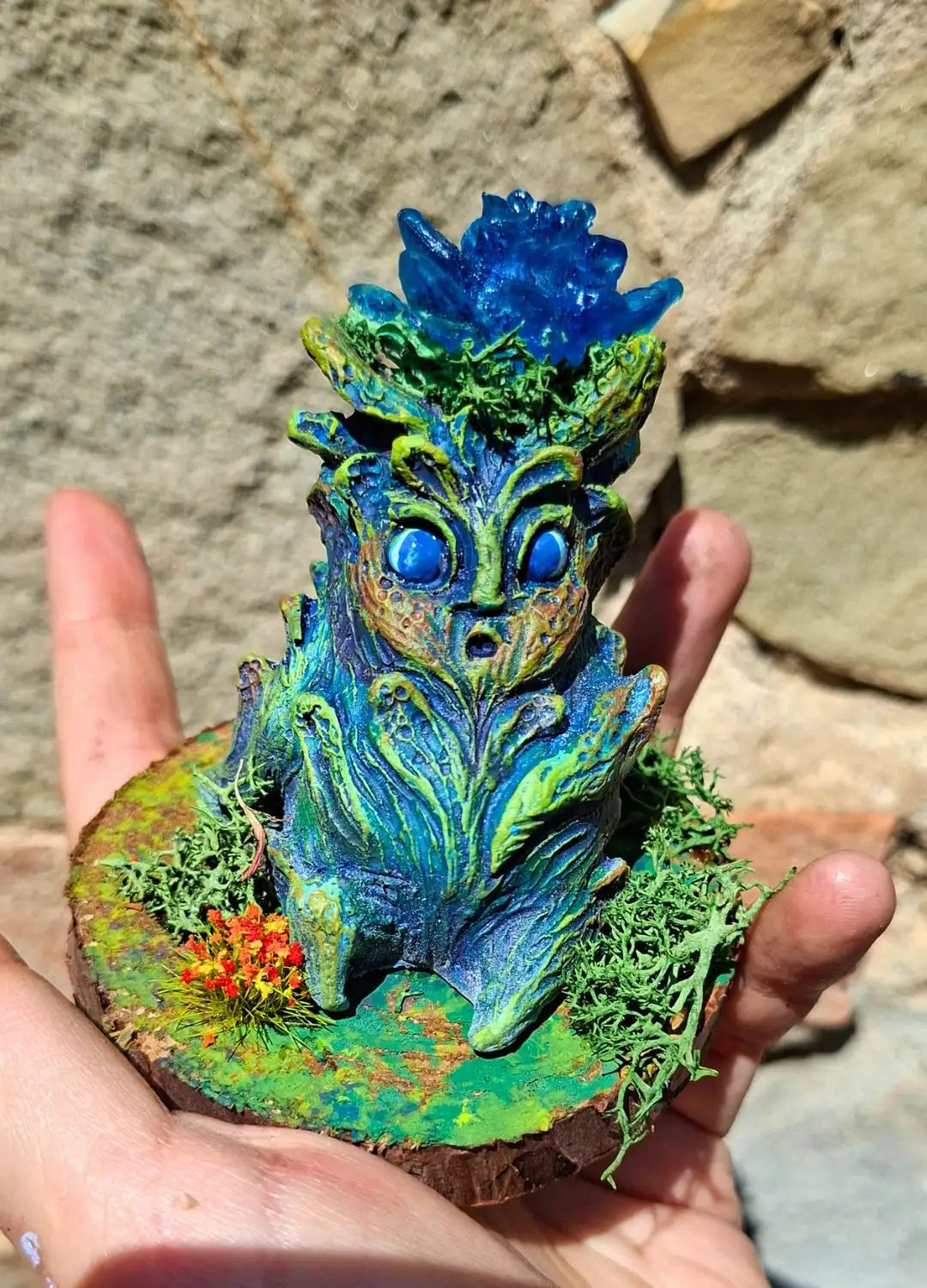 Decorated wooden display base with preserved flowers and lichen for the Lumen Mandrake.